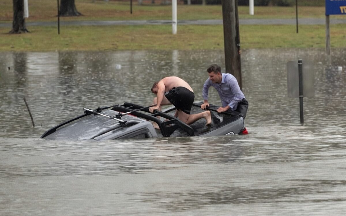 ABC-verslaggever redt man uit auto bij een overstroming in Morayfield