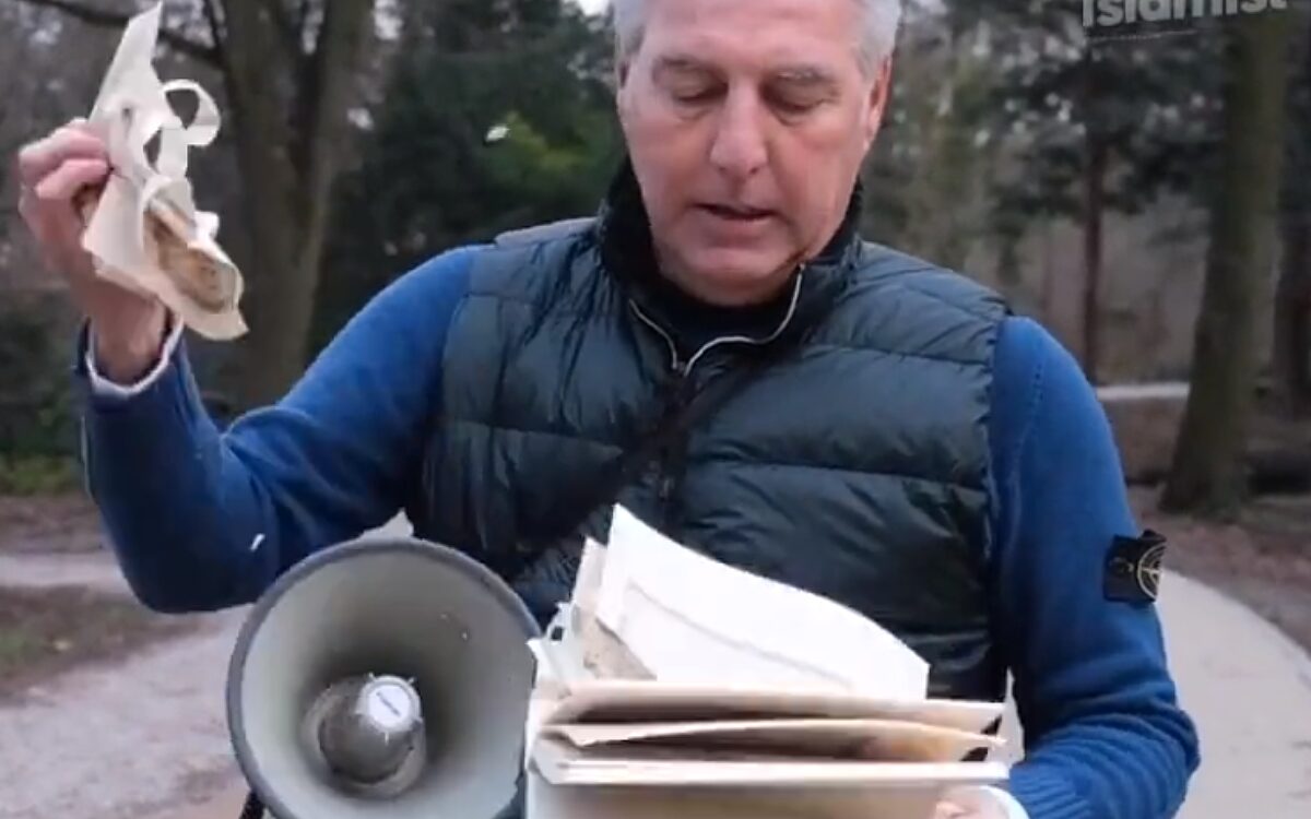 Pegida-voorman sleept koran aan hondenriem over straat in Arnhem